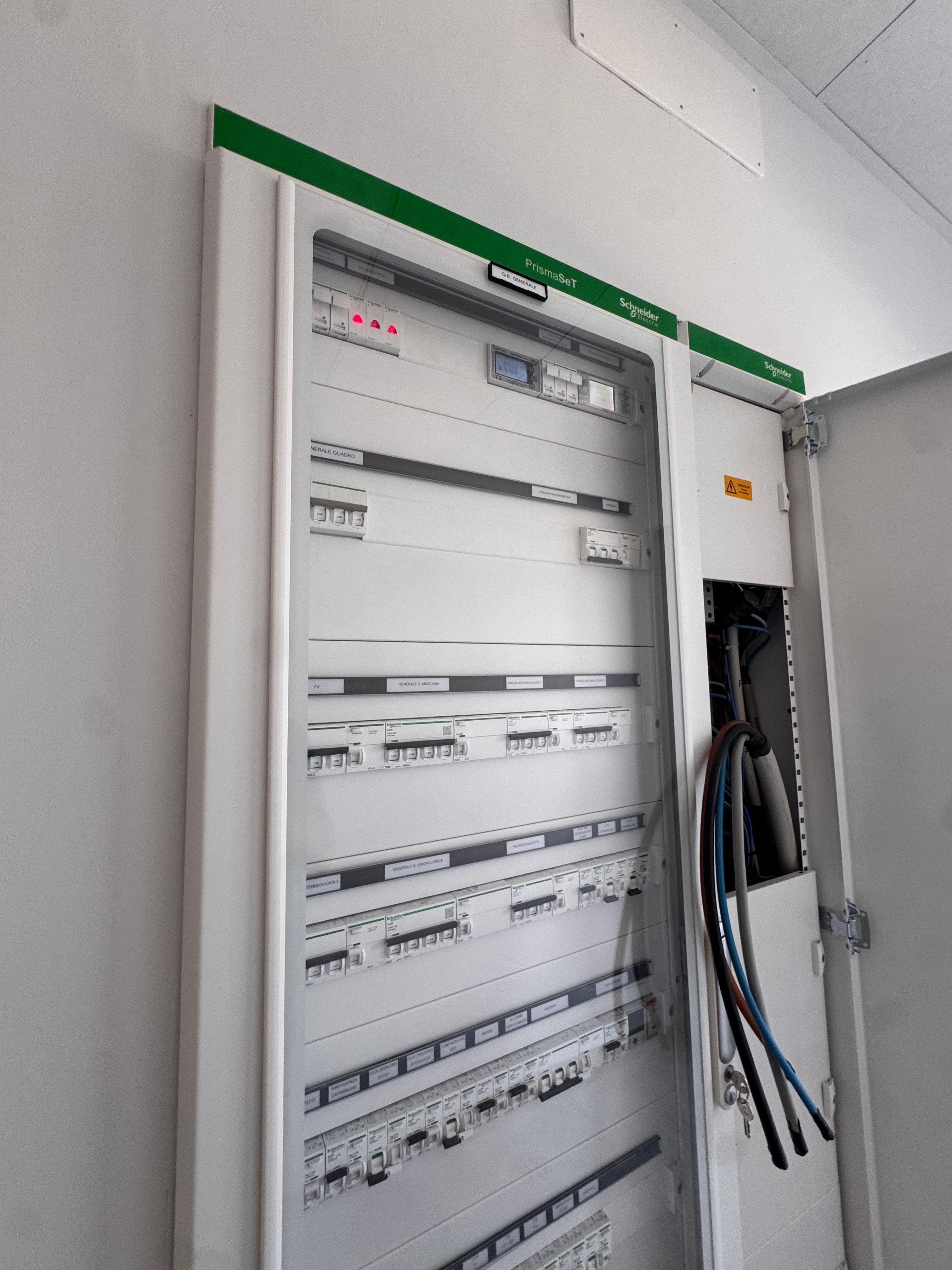 Quadro elettrico Schneider Electric PrismaSeT con interruttori automatici, spie luminose e cablaggio laterale esposto.